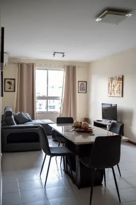a living room with a couch and a table and chairs at T2 com escritório - Férias Teletrabalho in Praia