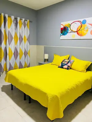 a bedroom with a yellow bed with a yellow bedspread at Large 1 bedroom Apt with sofa bed in Santa Maria
