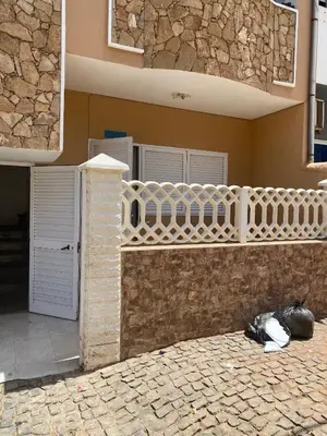 a building with a white fence on the side of it at Large 1 bedroom Apt with sofa bed in Santa Maria