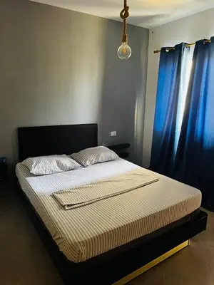 a bed in a bedroom with blue curtains at Santa Maria Central Stay in Santa Maria