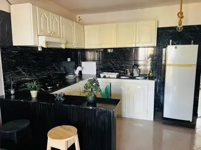 a kitchen with white cabinets and a white refrigerator at Santa Maria Central Stay in Santa Maria