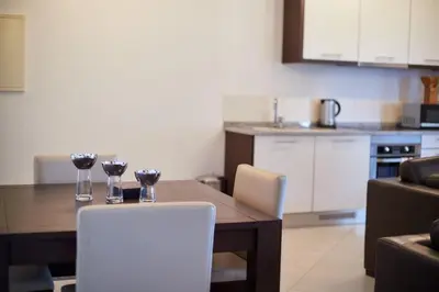 a kitchen with a table and two glasses of wine at Lux 1BR S Maria 90 Day Stay in Santa Maria