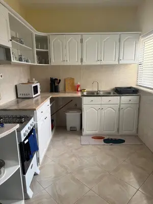 a kitchen with white cabinets and white appliances at Affordable Beach Town Apartment in Santa Maria