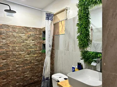 a bathroom with a toilet and a sink and a shower at Central 1-Bedroom Apartment near Sucupira Market in Praia