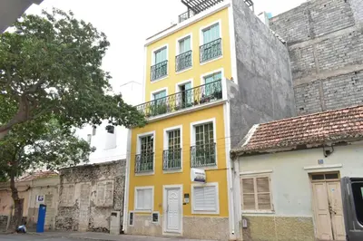 a yellow building with a balcony on top of it at Casa Berta - Downtown Apartment in Praia