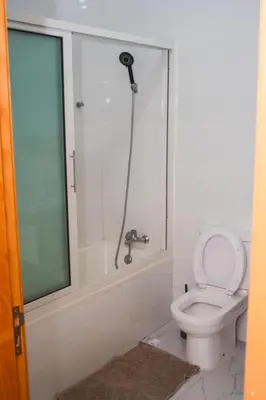 a bathroom with a shower with a toilet and a tub at Rooms in Apartment Morabeza in Praia Cidadela in Praia