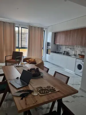 a kitchen with a wooden table with a laptop on it at Apartamento Cidade in Mindelo