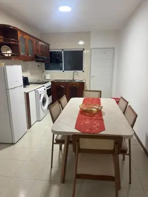 a kitchen with a table with chairs and a white refrigerator at Paz, Tranquilidade e Conforto in Espargos