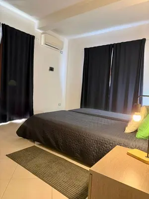 a bedroom with a large bed with black curtains at Estrela Mar - Wi-Fi included in Santa Maria