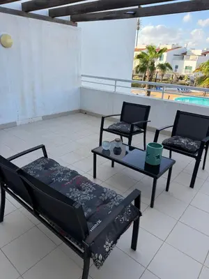 a balcony with a bed and two chairs and a table at Vila Verde TownHouse T53 by RPG Group in Santa Maria