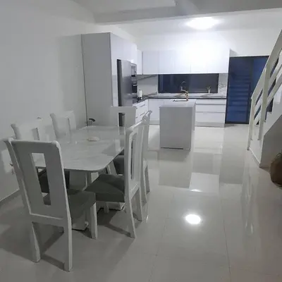 a dining room with a table and chairs and a kitchen at Apartamento Duplex Boa Vista in Sal Rei