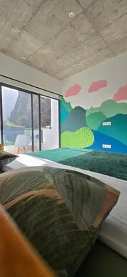 a bedroom with a bed with a painting on the wall at The Pink Banana in Paul