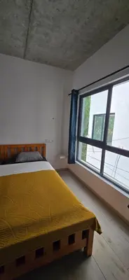a bedroom with a bed and a large window at The Pink Banana in Paul