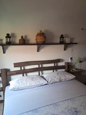 a bedroom with a bed with two shelves on the wall at Ibiscus Penthouse in Santa Maria