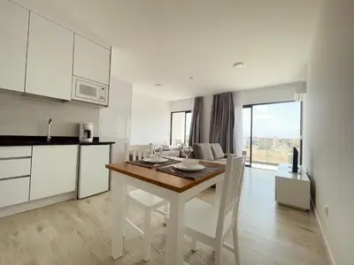 a kitchen and dining room with a table and a kitchen and a room with at Apartamento T0 - MedSal Residence in Prainha