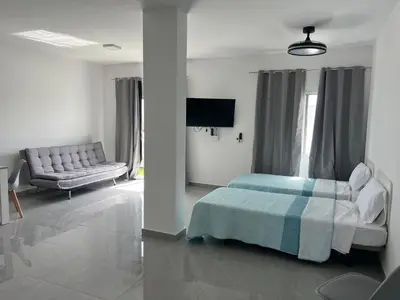 a bedroom with a bed and a couch at APARTAMENTOS COSTA MCC - New apartments near city center & beach in Santa Maria