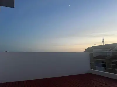 a white wall on a building with the sunset in the background at APARTAMENTOS COSTA MCC - New apartments near city center & beach in Santa Maria