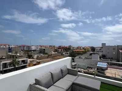 a balcony with a couch and a view of a city at APARTAMENTOS COSTA MCC - New apartments near city center & beach in Santa Maria