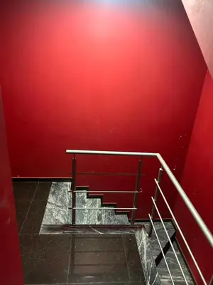 a staircase with a red wall and a metal railing at CasaTanha in Mindelo
