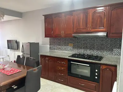 a kitchen with wooden cabinets and a table and a stove at CasaTanha in Mindelo