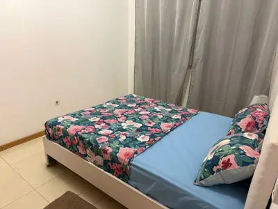 a bed in a room with a floral blanket on it at vitoria in Praia