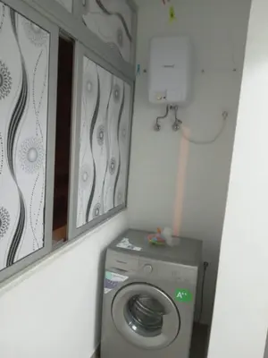 a small bathroom with a washing machine and a mirror at T3 Mindelo in Mindelo