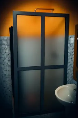 a glass door in a bathroom with a sink at Djabraba's kaminhu Double in Vila Nova Sintra