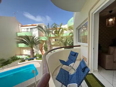 a balcony with blue chairs and a swimming pool at Isabel s Bay in Santa Maria