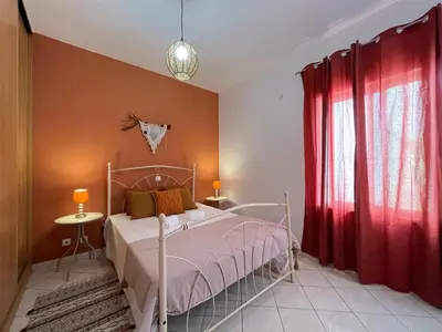 a bedroom with a bed and a red curtain at Isabel s Bay in Santa Maria