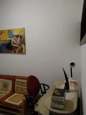 a room with a table and a desk with a computer at Apartamento T3 em Alto Miramar in Mindelo