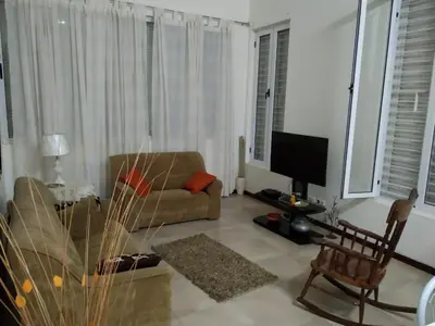 a living room with a couch and a television at Apartamento T3 em Alto Miramar in Mindelo