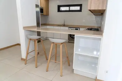 a kitchen with a counter and two stools at o som das ondas in Praia