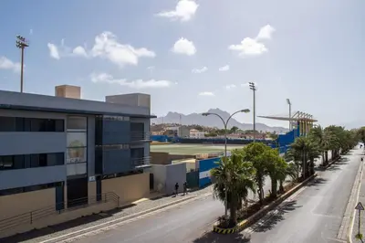 an empty street with palm trees and a building at Casa Miranda in Mindelo