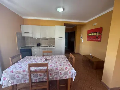 a kitchen with a table and chairs and a kitchen with white cabinets at Holiday Properties Tropicana in Santa Maria