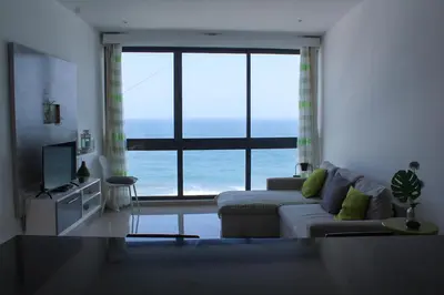 a living room with a couch and a large window at Casa Nova in Ribeira Grande