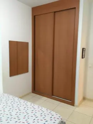 a wooden door in a room with a bed at Duplex Avenida Ilhéu Santa Maria, Palmarejo in Praia