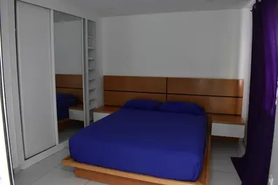 a bedroom with a blue bed and a mirror at Modern 2 bedroom apartment in Achada Santo António Praia'' Perto praca Di Nos