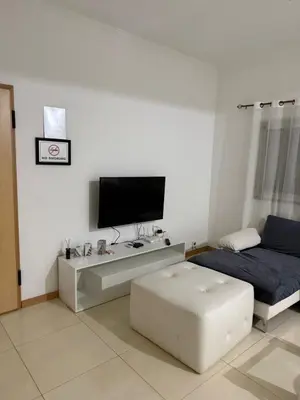 a living room with a tv and a couch at Gamboa t2 in Praia
