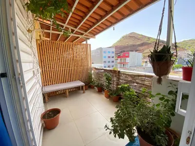 a balcony with a bench and potted plants on it at Guest house B&S in Praia