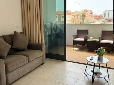 a living room with a couch and a table at JoLi Beach Apartments with Shared Pool in Santa Maria