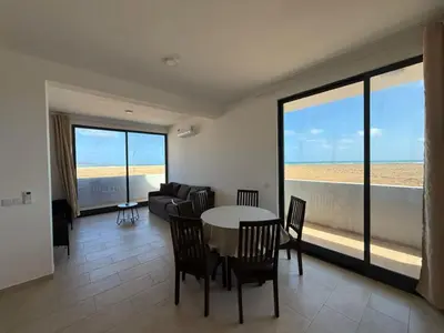 a living room with a table and chairs and a couch at JoLi Beach Apartments with Shared Pool in Santa Maria