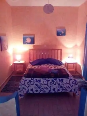 a bedroom with a bed and two lamps on two tables at Djabraba's Hiker's Suite in Garça