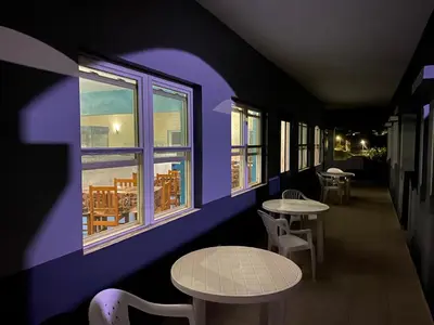 a purple room with tables and chairs and windows at Djabraba's Hiker's Suite in Garça