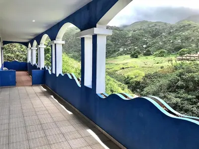 a hallway with a blue wall with a view of a mountain at Djabraba's Hiker's Suite in Garça