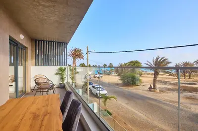 a balcony with a wooden table and a view of a street at Sal Sol & Mar - Flor de Sal in Santa Maria