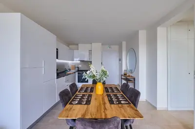 a dining room table with chairs and a vase with flowers at Sal Sol & Mar - Flor de Sal in Santa Maria