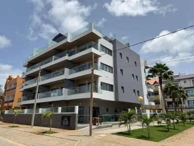 a white building with palm trees in front of it at Sal Sol & Mar - Larimar in Santa Maria