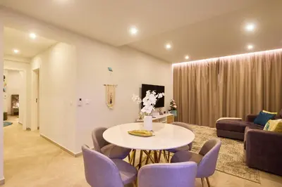 a living room with a table and purple chairs at Sal Sol & Mar - Larimar in Santa Maria