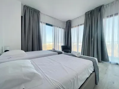 a bedroom with two white beds and large windows at T1 panorâmico no Medsal Residence in Santa Maria