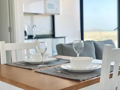 a wooden table with two wine glasses on top of it at T1 panorâmico no Medsal Residence in Santa Maria